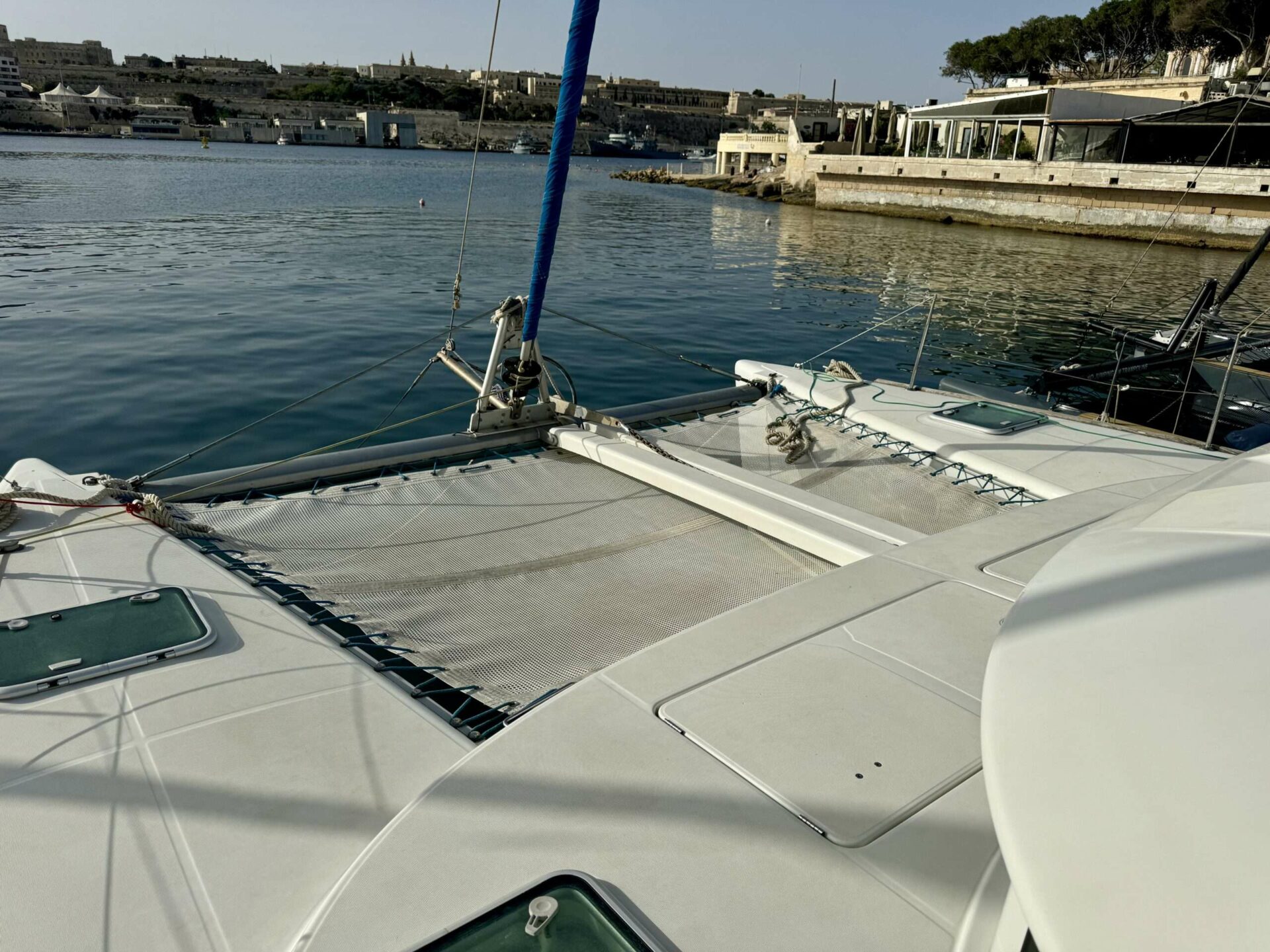 Bow trampoline netting on Cicciolina Mia catamaran, Valletta harbour in the background