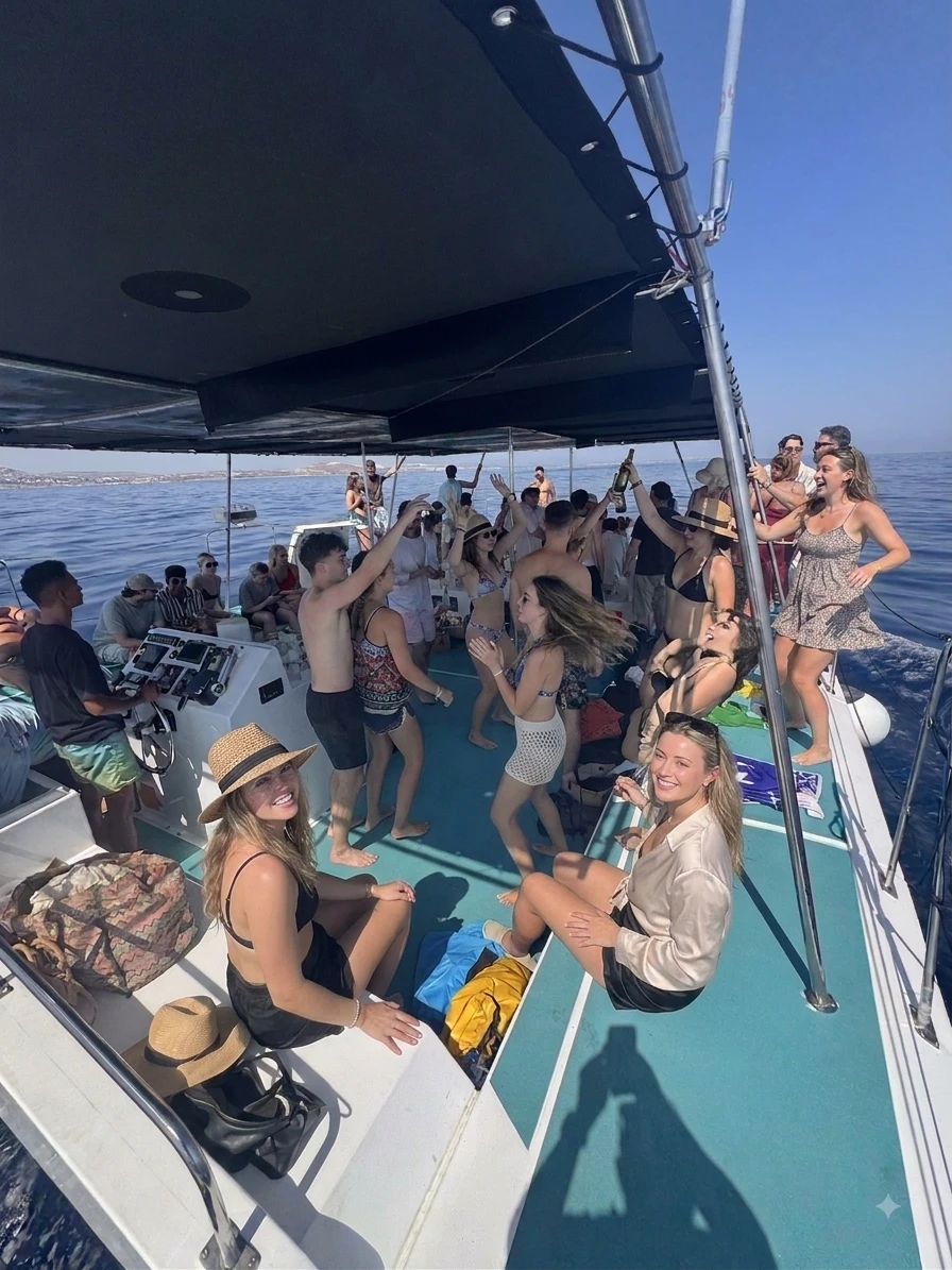 Baile y celebración en grupo a bordo del catamarán Playtime durante una fiesta en barco en Malta.