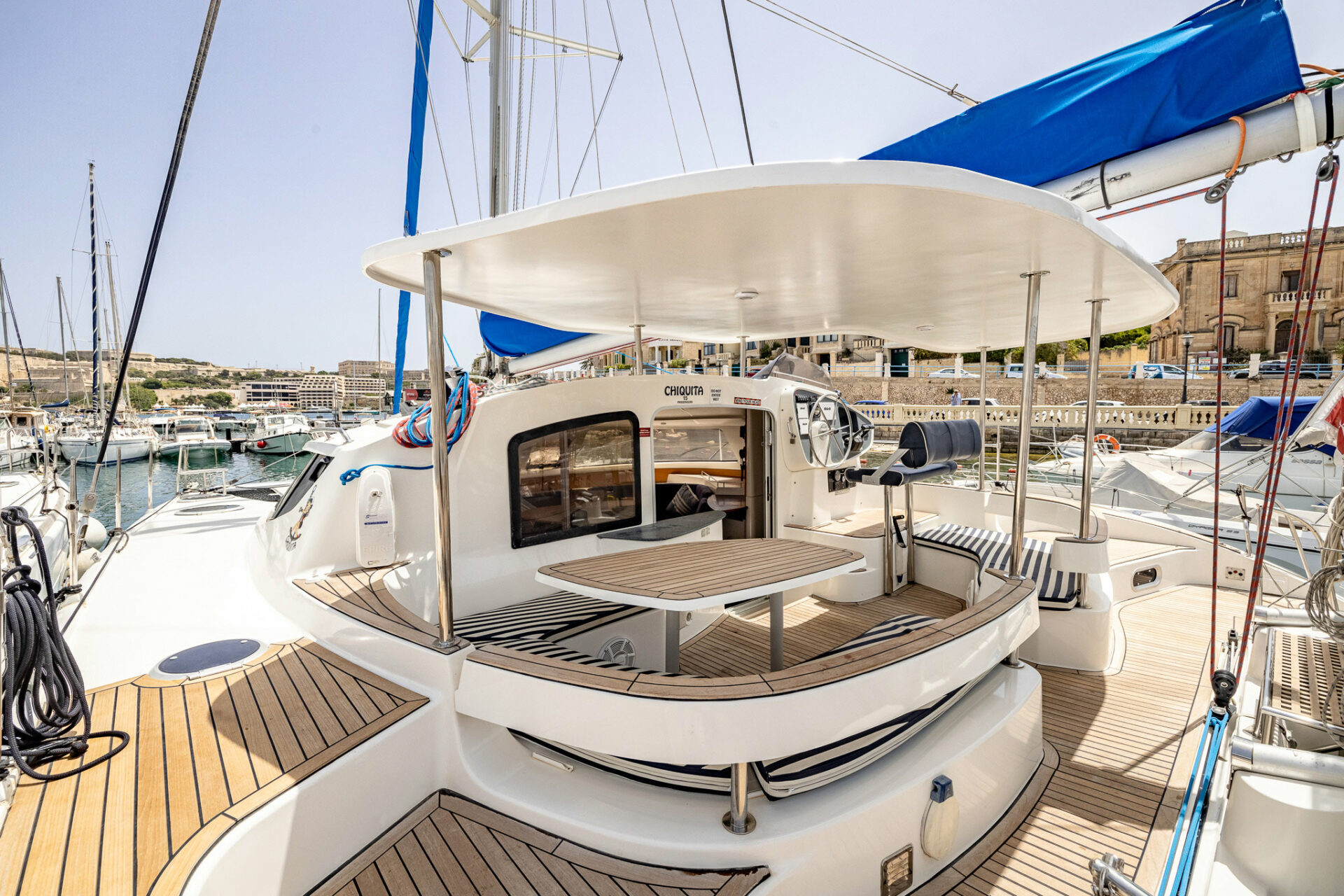 Das Cockpit und der Essbereich im Freien des Chiquita-Katamarans liegen in einem Yachthafen in Malta vor Anker.
