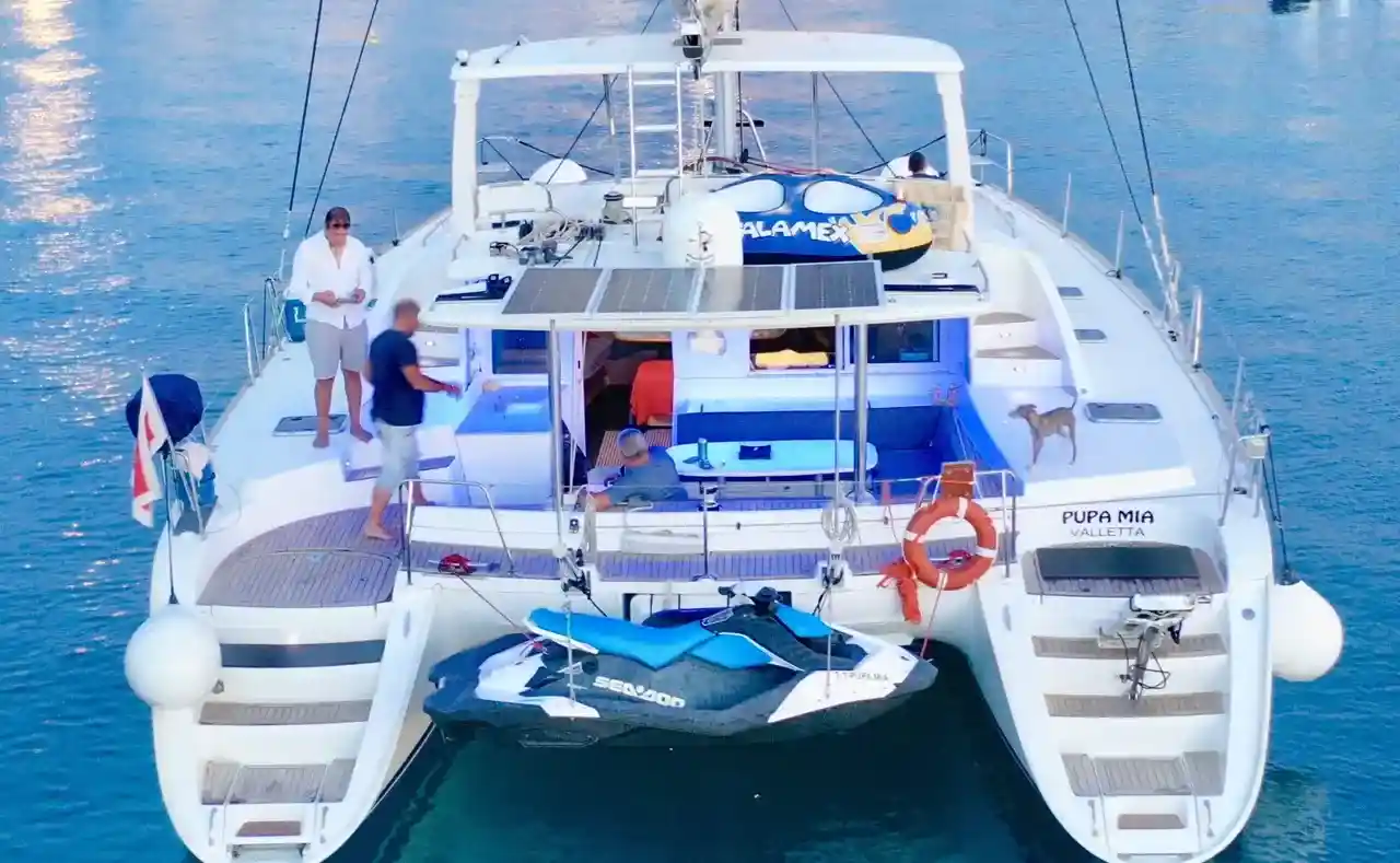 Rear view of Pupa Mia catamaran with a jet ski docked at the swim platform