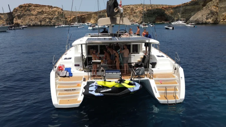 Siesta Mia catamaran anchored at the Blue Lagoon with a jet ski at the swim platform