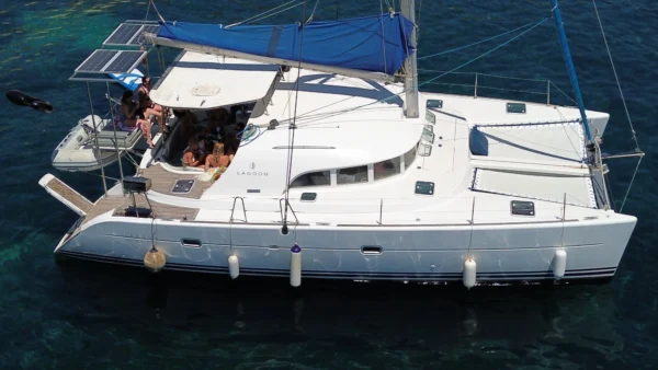Cicciolina Mia catamaran anchored in clear Malta water with guests on deck