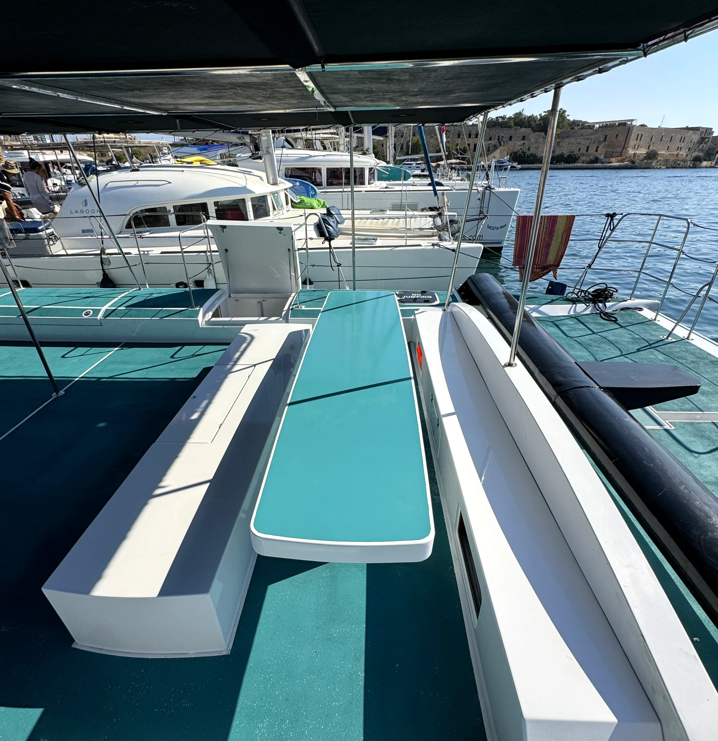 Banco con asientos y espacio de almacenamiento en la cubierta del catamarán Playtime en Roland Marina.